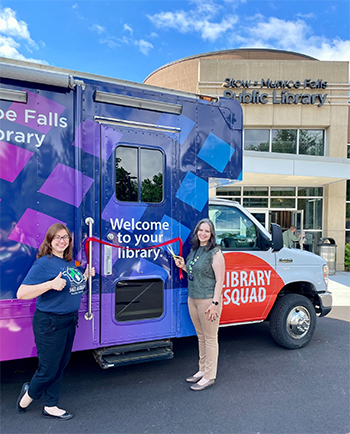 Bookmobile 2024 Gale Koritanksy, left, gives a thumbs up as Amanda Rome, right, cuts a red ribbon stretching across the door of the bookmobile