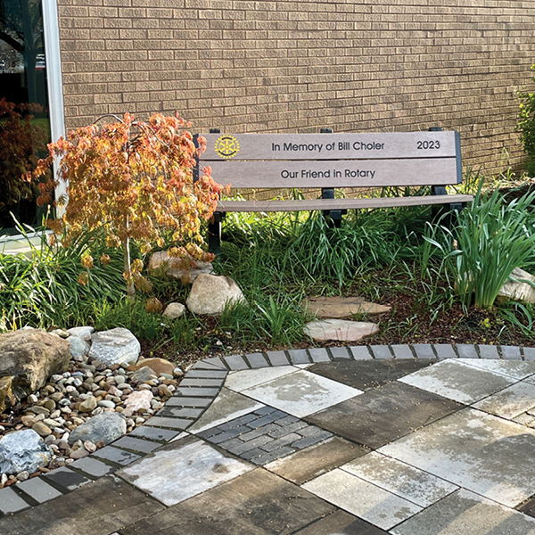 a memorial bench in a garden with multi-tonal pavers
